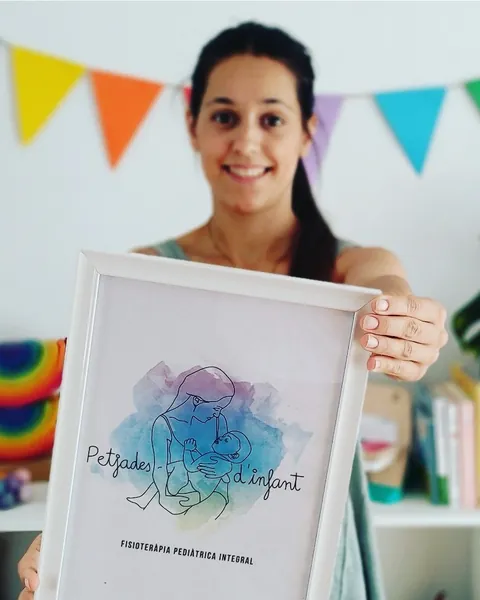 La fisioterapeuta de Petjades d'infant amb el quadre del logotip